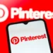 Pinterest logo displayed on a smartphone screen with the Pinterest brand logo in the background, representing the platform’s role in digital search and discovery.