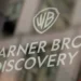 Warner Bros. Discovery logo displayed on a glass surface, representing the global media and entertainment company.